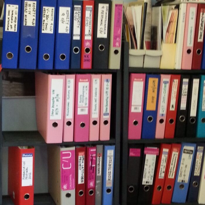 A shelf full of colour-coded binders.